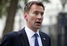 How many British politicans wearing “NHS 70” badges also own interests in Privatised Healthcare?